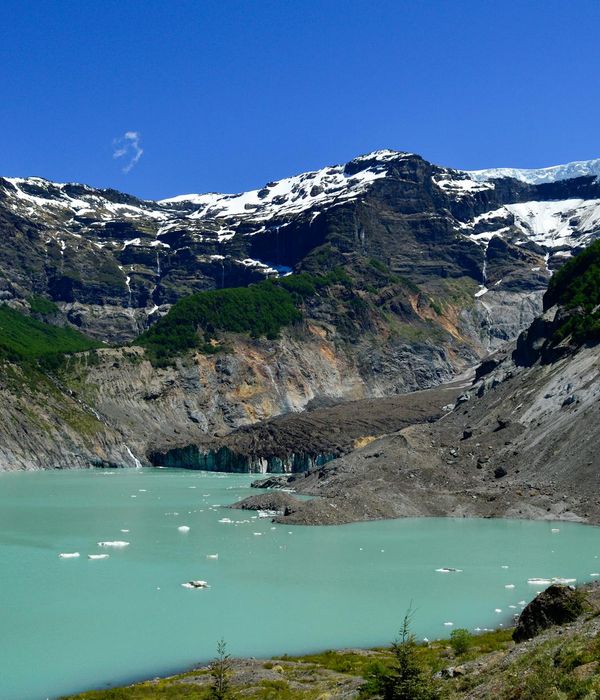 Crystal clear turquoise waters of Big Almaty Lake nestled between snow-capped mountains